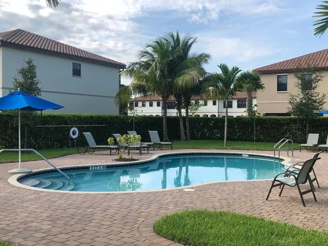 a view of a house with swimming pool and sitting area