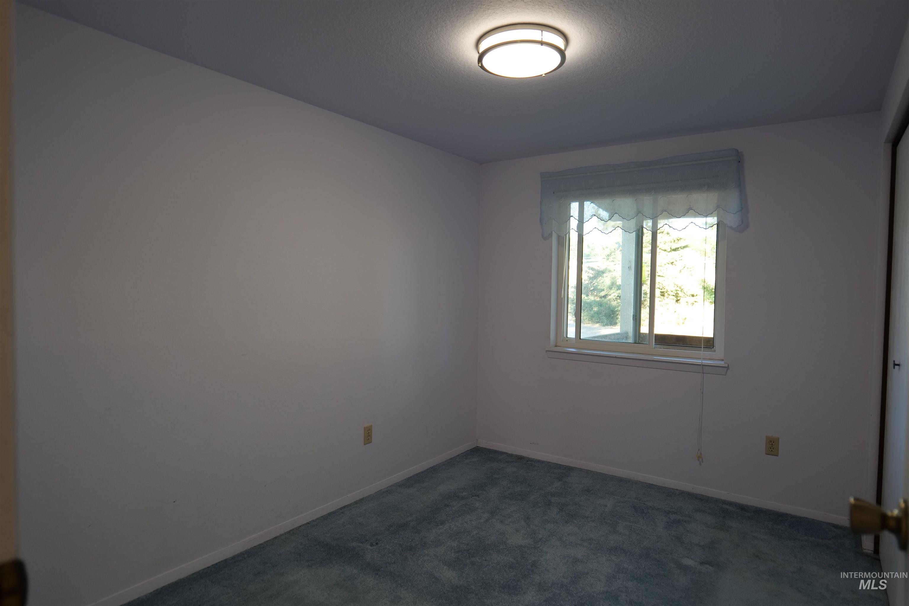 1485 East 9th Street Weiser, ID 83672 - Photo 4 of 18 Light-filled room featuring a single window, recessed lighting, and soft blue carpeting