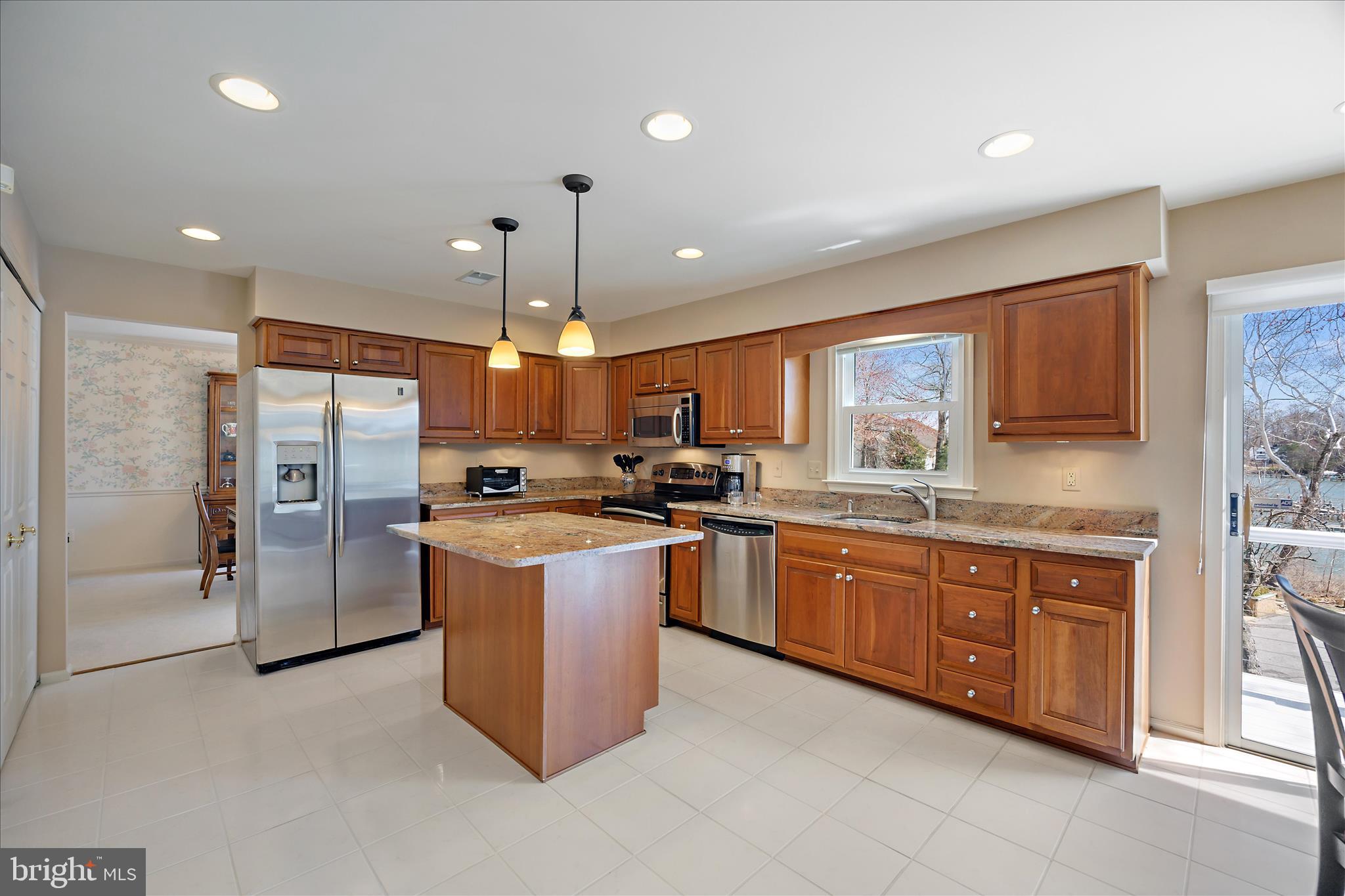 253 Milthorn Court Riva, MD 21140 - Photo 14 of 71 a large kitchen with stainless steel appliances kitchen island granite countertop a refrigerator a sink a stove and a microwave