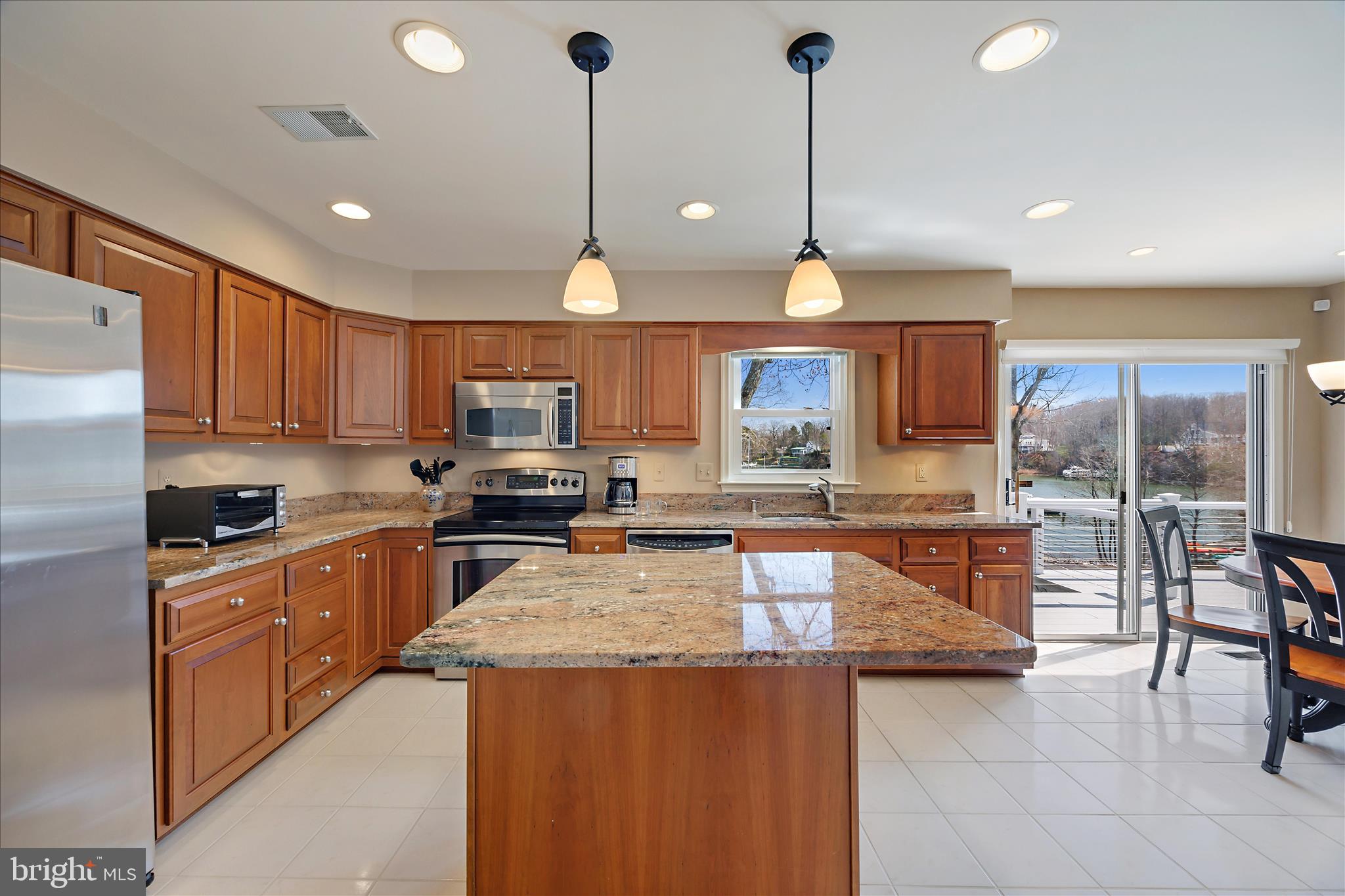 253 Milthorn Court Riva, MD 21140 - Photo 16 of 71 a kitchen with granite countertop a stove a sink a oven a dining table and chairs