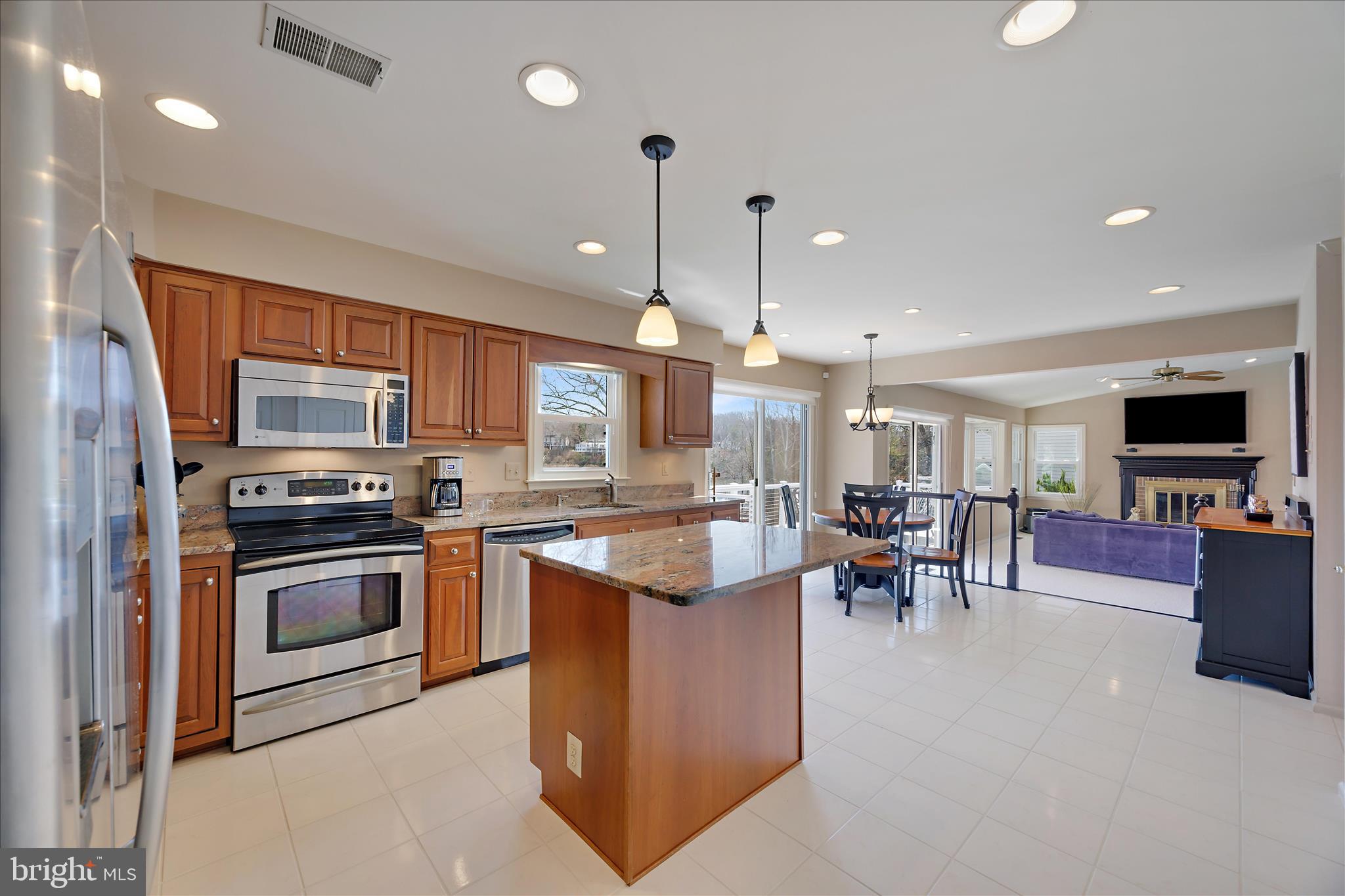 253 Milthorn Court Riva, MD 21140 - Photo 19 of 71 a kitchen with stainless steel appliances granite countertop a stove top oven a sink a dining table and chairs