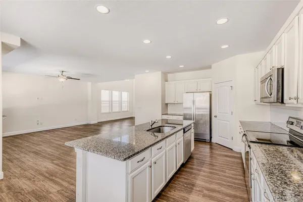 a kitchen with stainless steel appliances granite countertop a sink stove and refrigerator