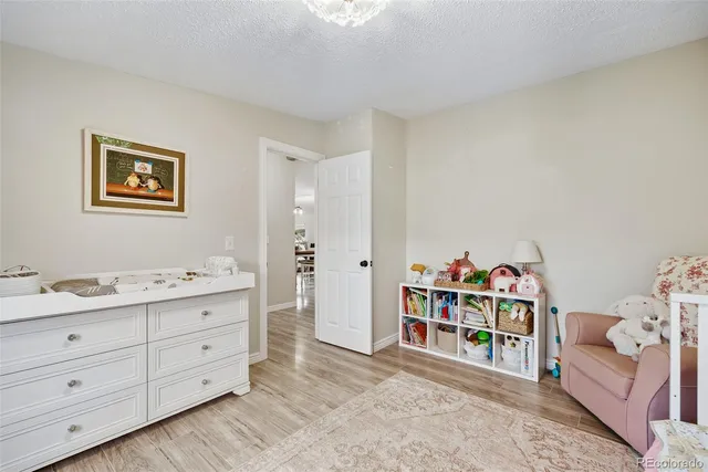 a room with a baby bed and a couch