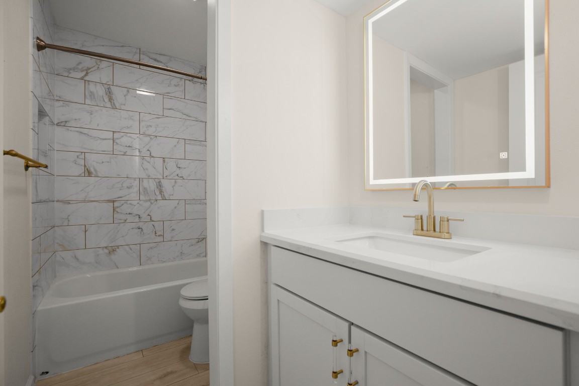 620 South 1st Street, Unit 315 Austin, TX 78704 - Photo 14 of 17 a bathroom with a granite countertop sink a toilet and shower