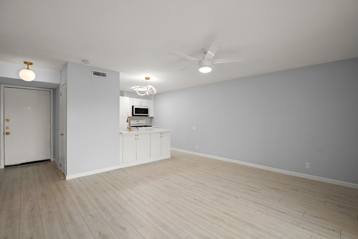 620 South 1st Street, Unit 315 Austin, TX 78704 - Photo 7 of 17 a view of a kitchen with wooden floor and a refrigerator
