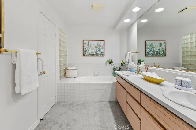 a bathroom with a granite countertop sink and a bathtub