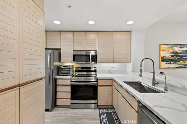 a kitchen with stainless steel appliances granite countertop a stove a sink and a microwave