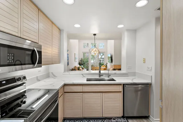a kitchen with stainless steel appliances granite countertop a sink and a stove