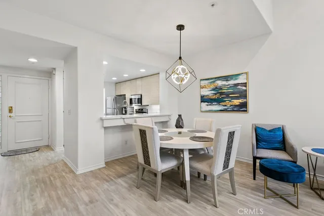 a view of a dining room and a livingroom with furniture wooden floor a chandelier