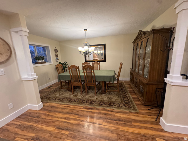 655 North 8th East Preston, ID 83263 - Photo 2 of 32 Dining area with ornate columns, wood finished floors, hanging lights, and a textured ceiling