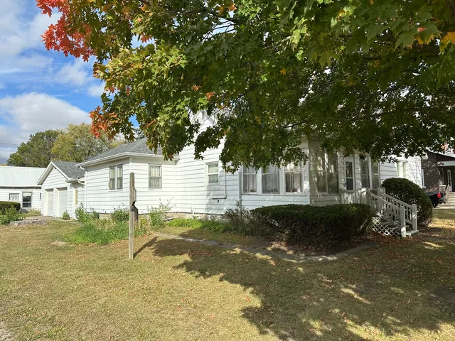 a backyard of a house with table and chairs