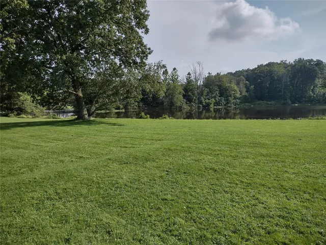 a view of a green field with wooden fence