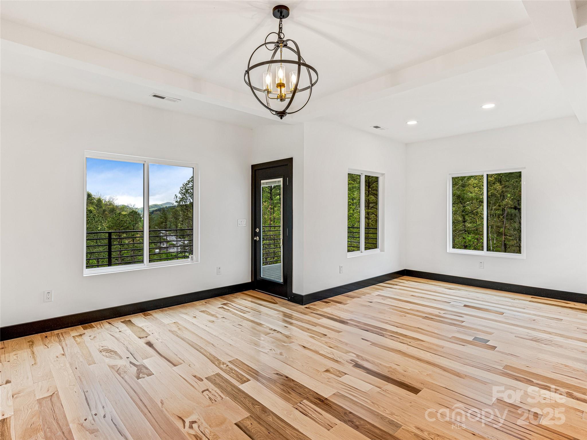 74 Jeranna Road Mills River, NC 28759 - Photo 25 of 42 a view of an empty room with window wooden floor and a kitchen view