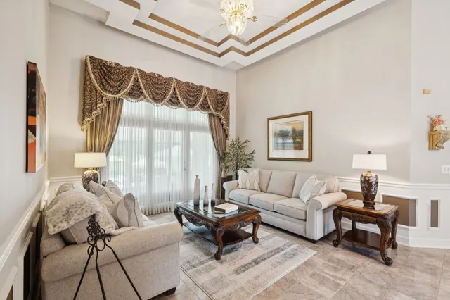 a dining room with furniture a chandelier and a large window
