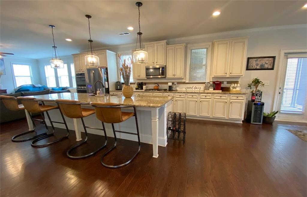 4806 Ralin Court Southwest Atlanta, GA 30331 - Photo 18 of 104 a kitchen with stainless steel appliances granite countertop a stove a sink a dining table and chairs with wooden floor