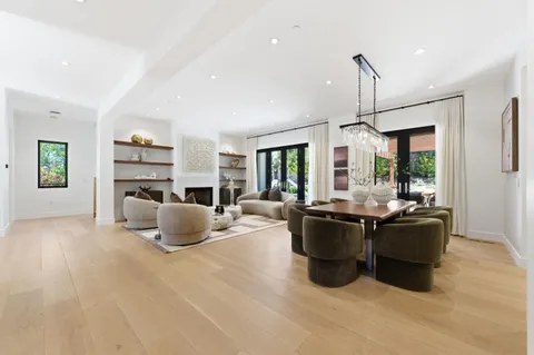 a living room with furniture a large window and chandelier