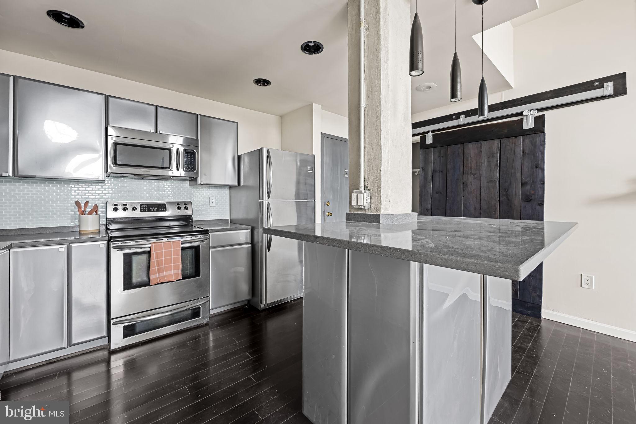 a kitchen with stainless steel appliances a refrigerator and a stove top oven