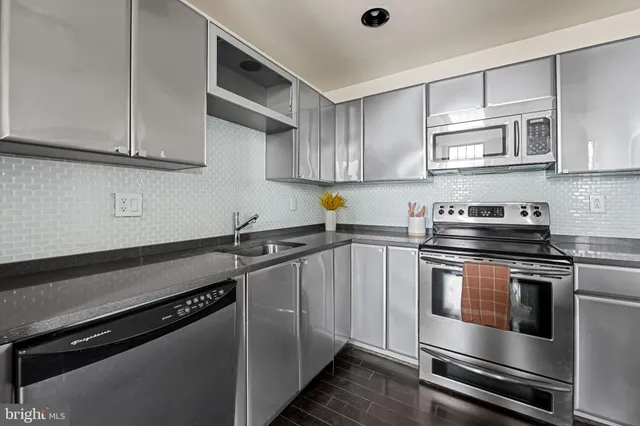 a kitchen with stainless steel appliances granite countertop a sink a stove and cabinets