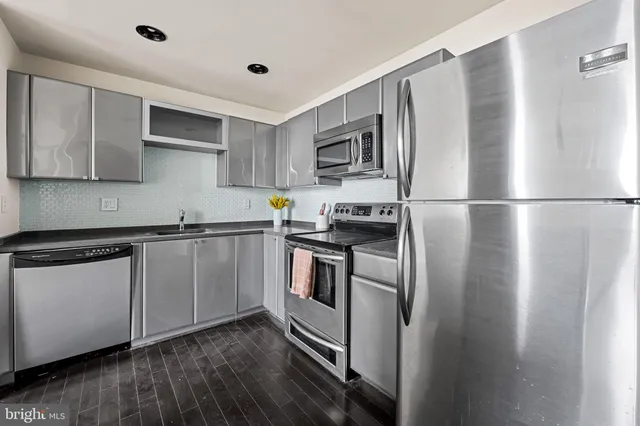 a kitchen with stainless steel appliances a refrigerator sink and microwave