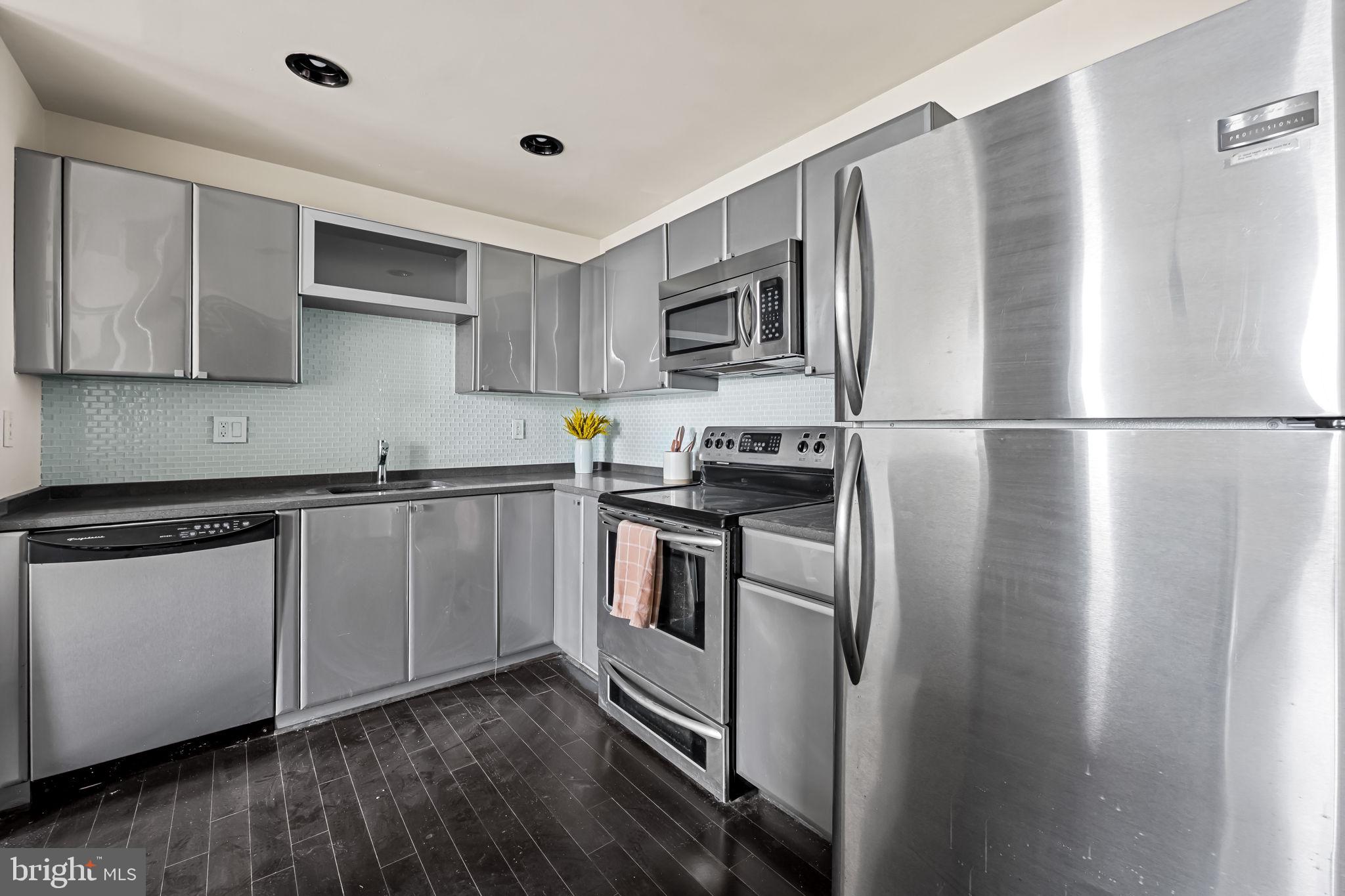 1011 Hunter Street, Unit A4 Baltimore, MD 21202 - Photo 22 of 34 a kitchen with stainless steel appliances a refrigerator sink and microwave