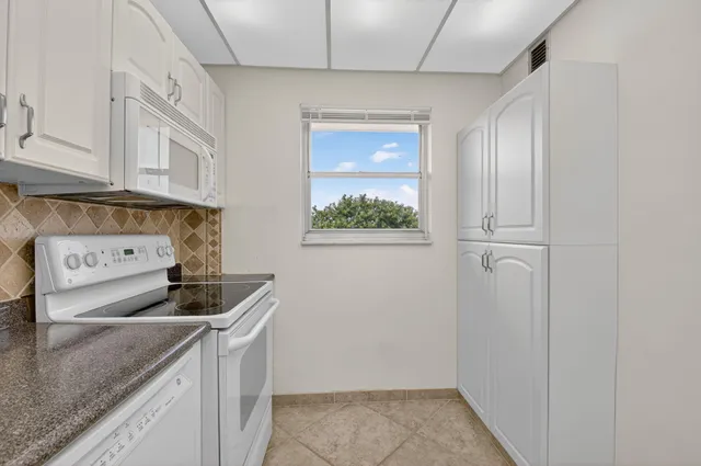 a kitchen with stainless steel appliances granite countertop a sink a stove and a microwave oven