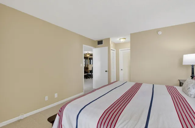 a bedroom with a bed and a lamp with the bathroom