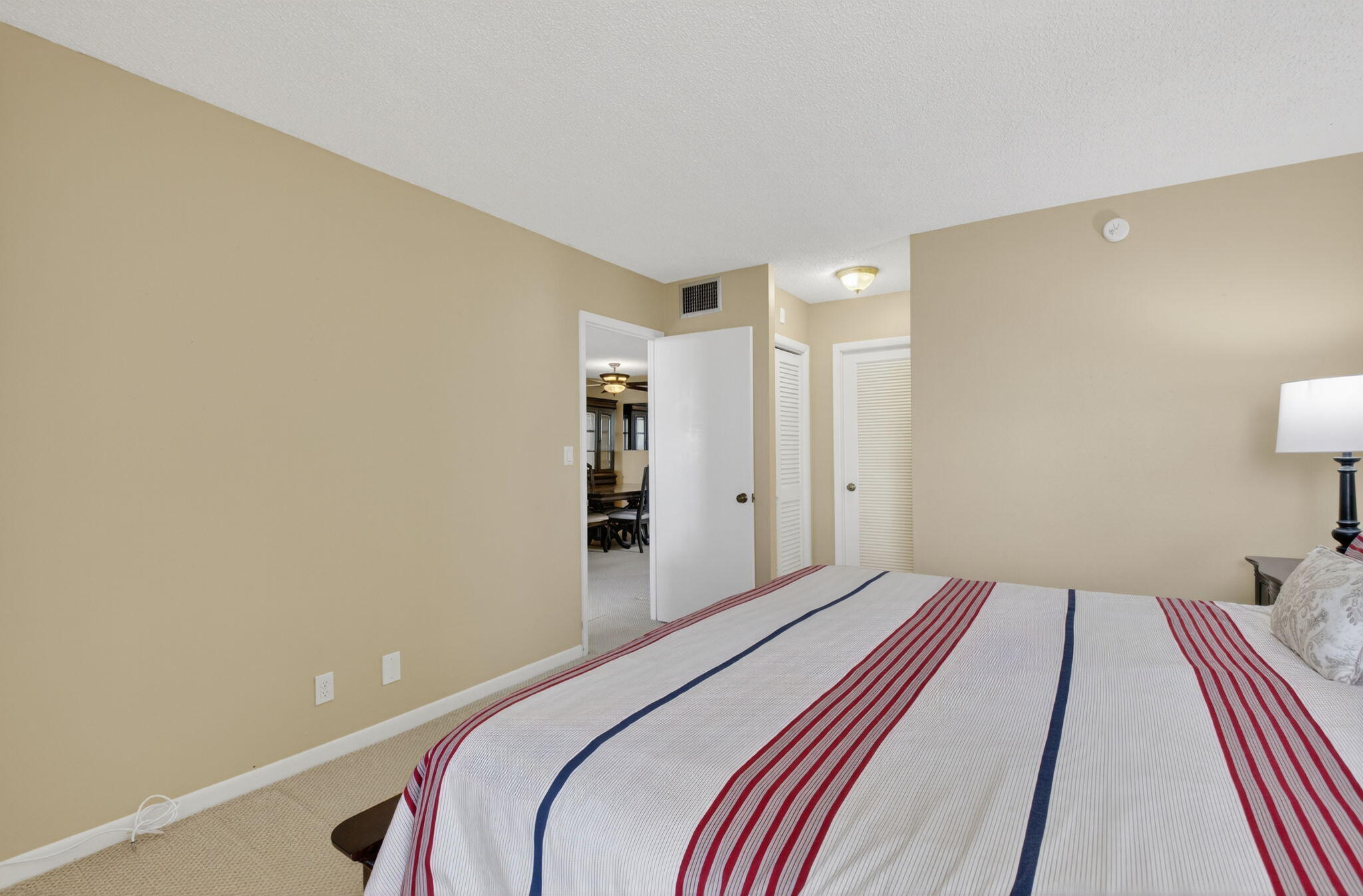 555 Northwest 4th Avenue, Unit 4230 Boca Raton, FL 33432 - Photo 16 of 38 a bedroom with a bed and a lamp with the bathroom