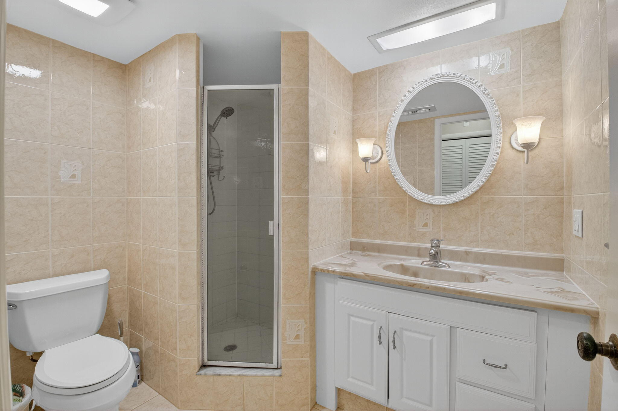 555 Northwest 4th Avenue, Unit 4230 Boca Raton, FL 33432 - Photo 17 of 38 a bathroom with a toilet a sink a vanity and mirror