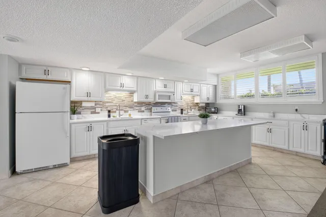 a kitchen with a sink window and white stainless steel appliances