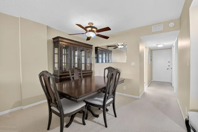 a view of a dining room with furniture and a chandelier fan