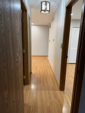 a view of hallway with wooden floor and staircase