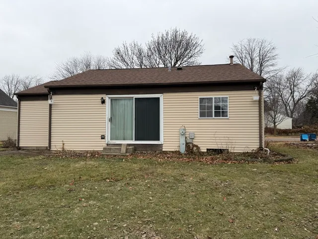 a view of a yard in front of a house with a large tree