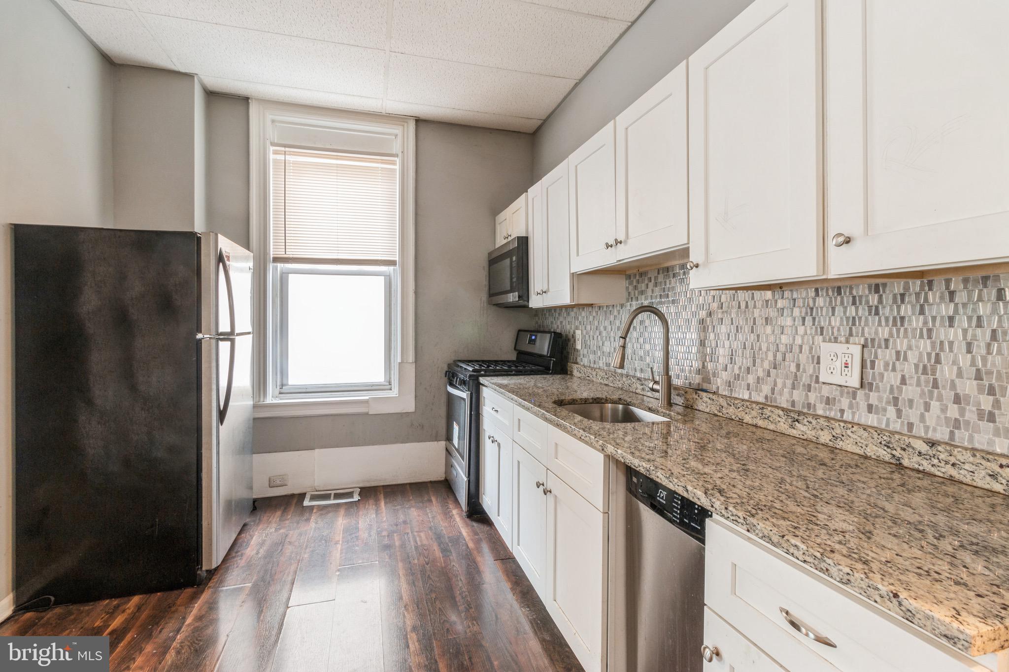 525-527 Penn Street, Unit 1A Camden, NJ 08102 - Photo 3 of 12 a kitchen with stainless steel appliances granite countertop a sink stove and refrigerator