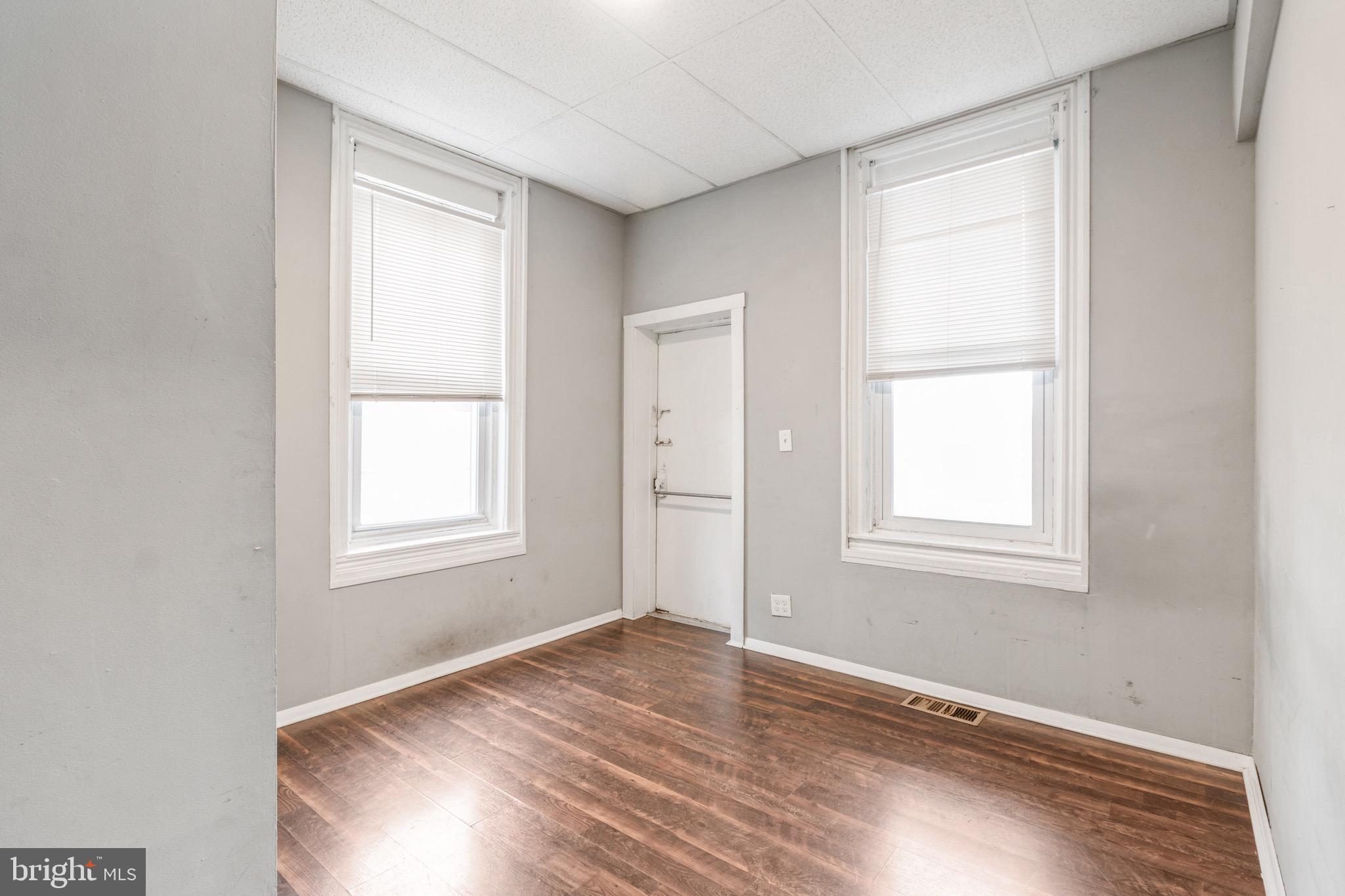 525-527 Penn Street, Unit 1A Camden, NJ 08102 - Photo 9 of 12 an empty room with wooden floor and windows