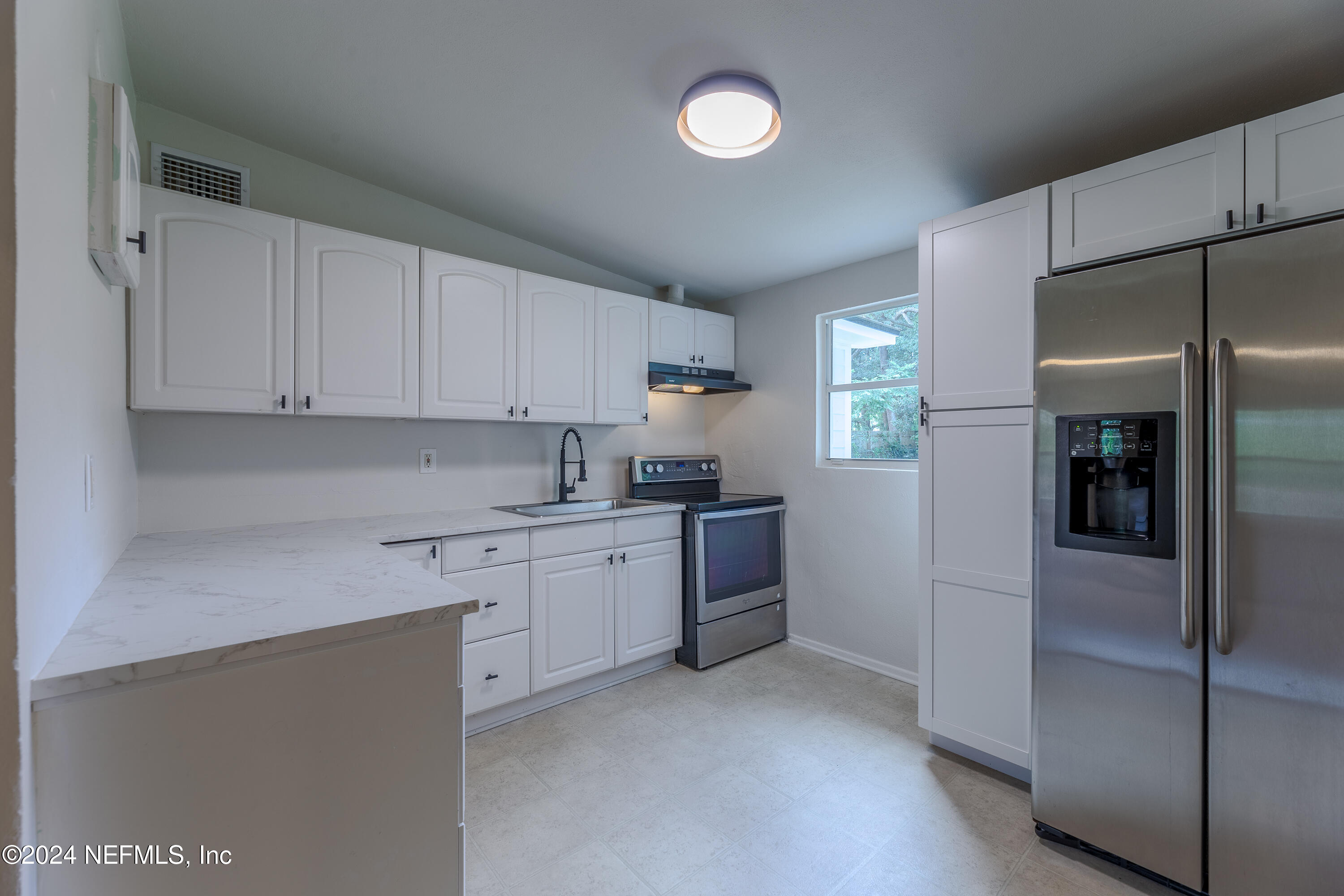 90 Spring Street St. Augustine, FL 32084 - Photo 9 of 24 a kitchen with a refrigerator sink and cabinets