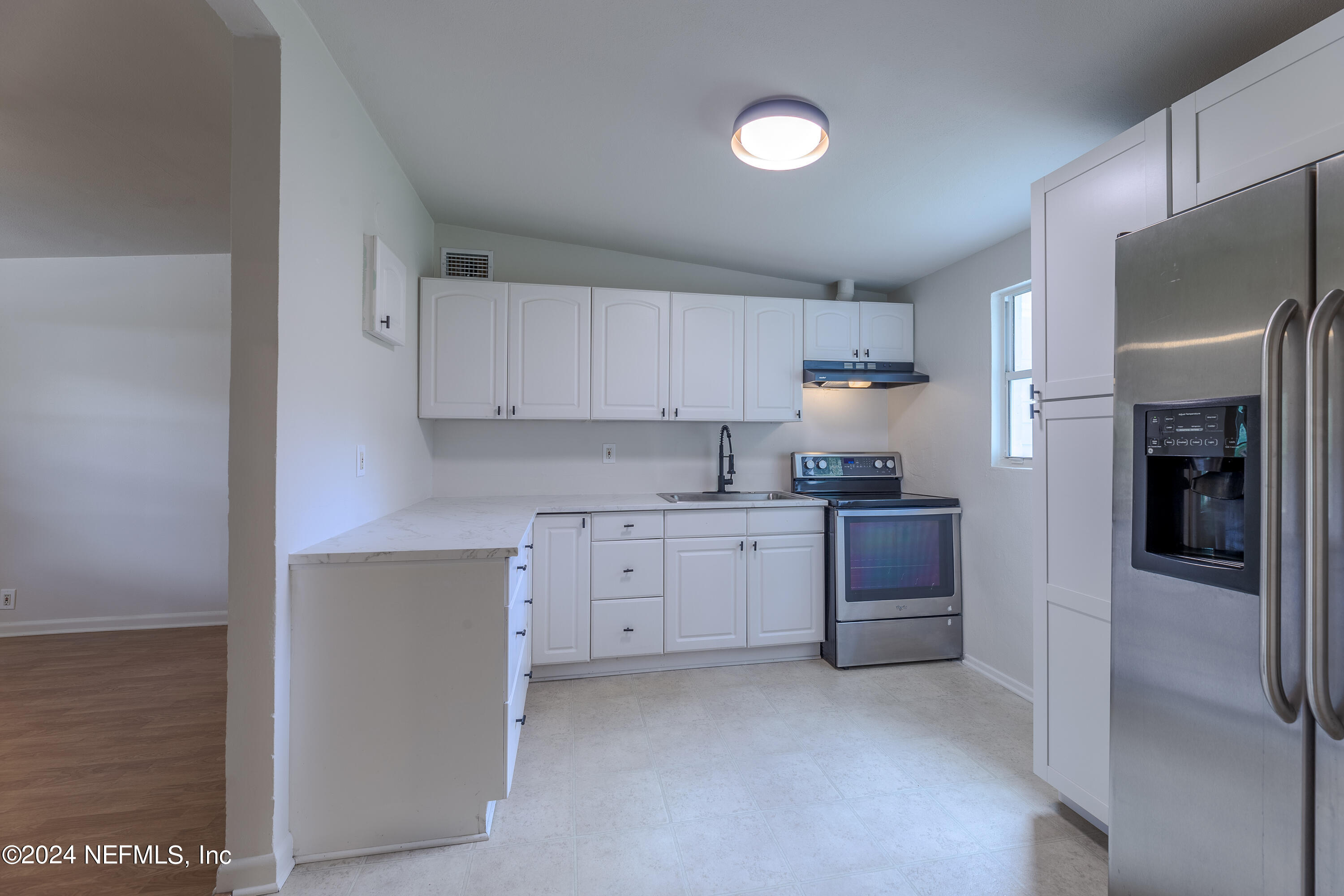 90 Spring Street St. Augustine, FL 32084 - Photo 10 of 24 a kitchen with a refrigerator stove top oven and cabinets