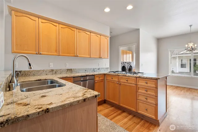 a kitchen with granite countertop a sink a counter space and cabinets