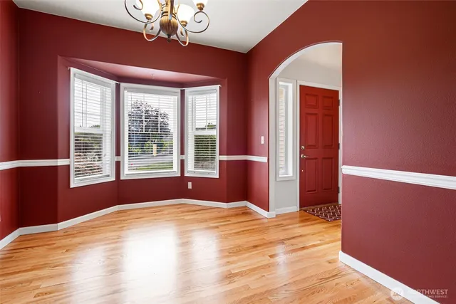 a bedroom with wooden floor closet and a chandelier
