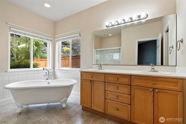 a spacious bathroom with a double vanity sink a mirror and a bathtub