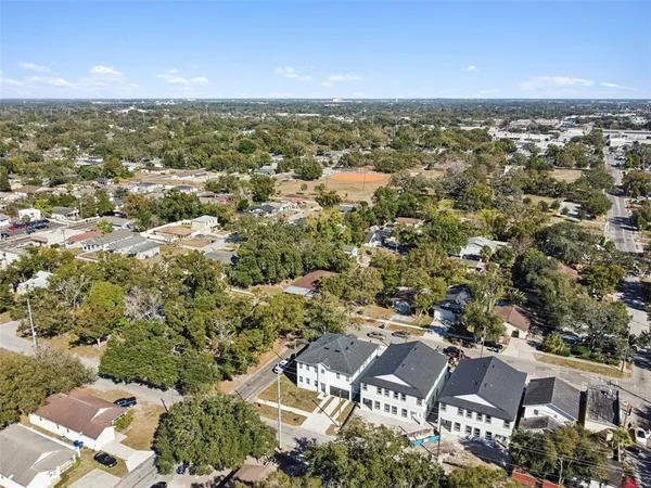 an aerial view of residential houses with outdoor space and parking