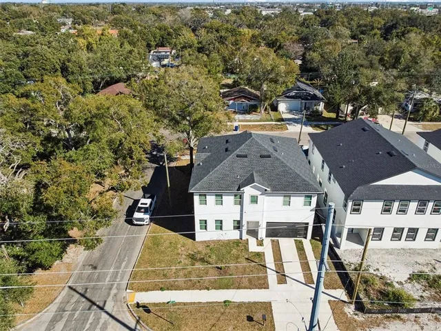 an aerial view of residential houses with outdoor space and parking