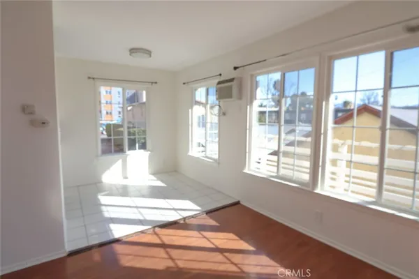 a view of an empty room with wooden floor and a porch