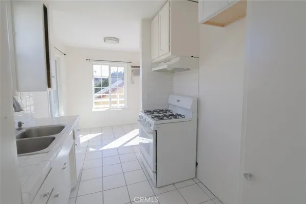 a room with granite countertop a sink and a window