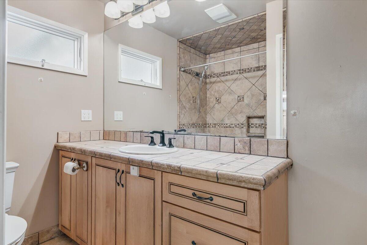 230 North D Street Lompoc, CA 93436 - Photo 18 of 29 a bathroom with a granite countertop sink a toilet and a mirror