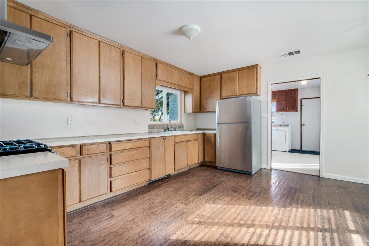 230 North D Street Lompoc, CA 93436 - Photo 9 of 29 a kitchen with a refrigerator sink and cabinets
