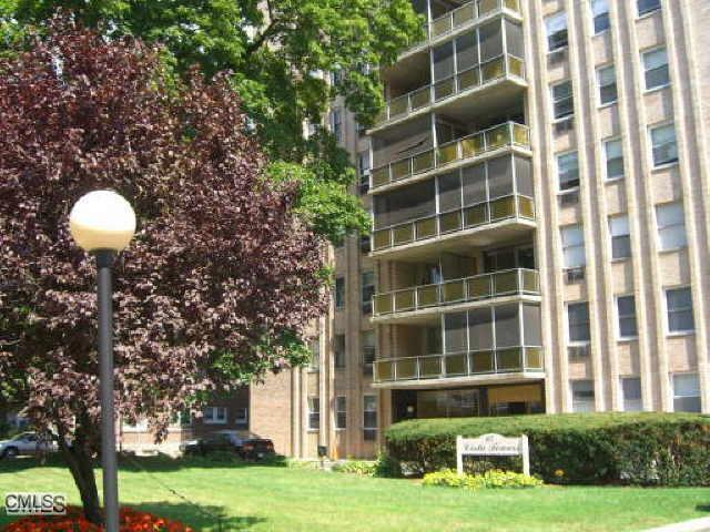 65 Glenbrook Road, Unit 7C Stamford, CT 06902 - Photo 1 of 1 a front view of a building with garden