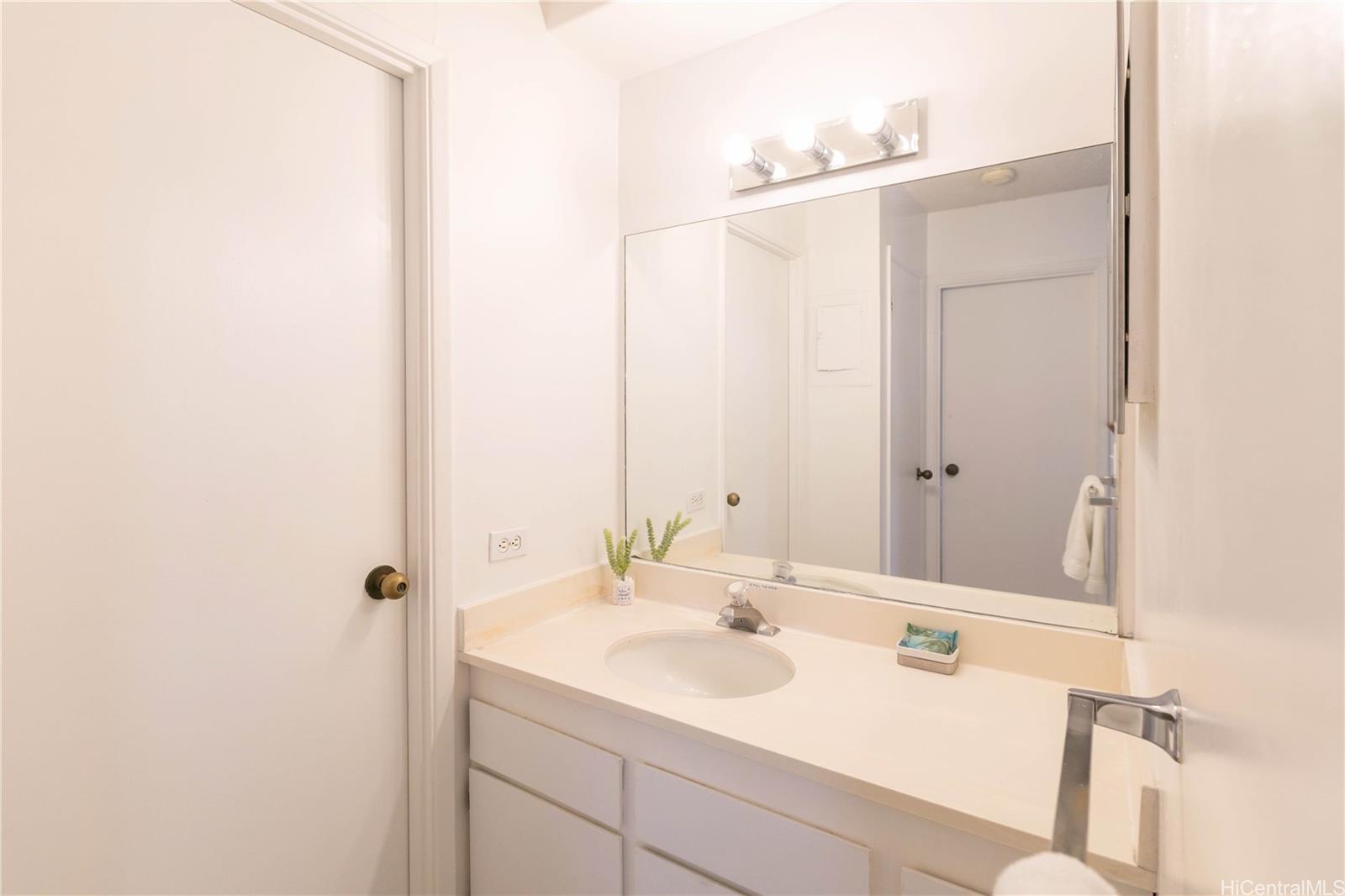 2240 Kūhiō Avenue, Unit 2608 Honolulu, HI 96815 - Photo 11 of 25 a bathroom with a sink and a mirror