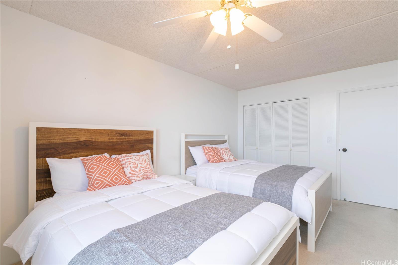 2240 Kūhiō Avenue, Unit 2608 Honolulu, HI 96815 - Photo 15 of 25 a bedroom with two beds and a chandelier