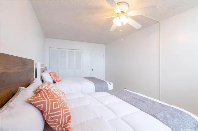 a bedroom with a bed and a chandelier fan