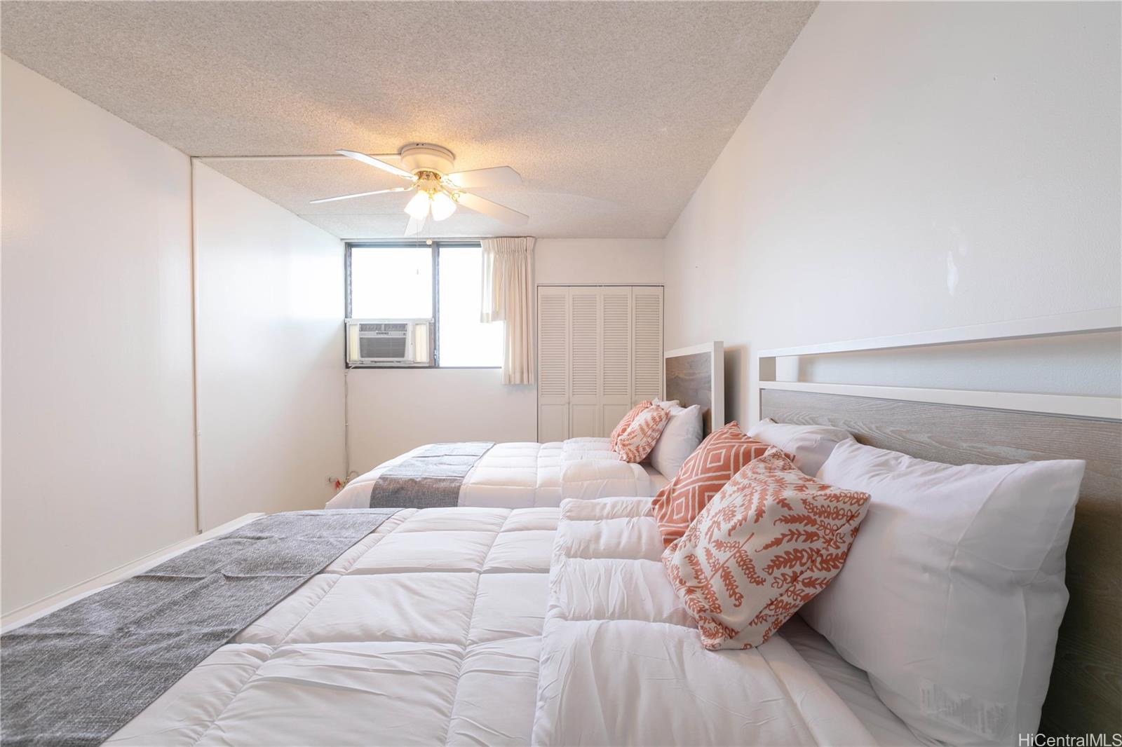 2240 Kūhiō Avenue, Unit 2608 Honolulu, HI 96815 - Photo 17 of 25 a bedroom with a bed and a chandelier